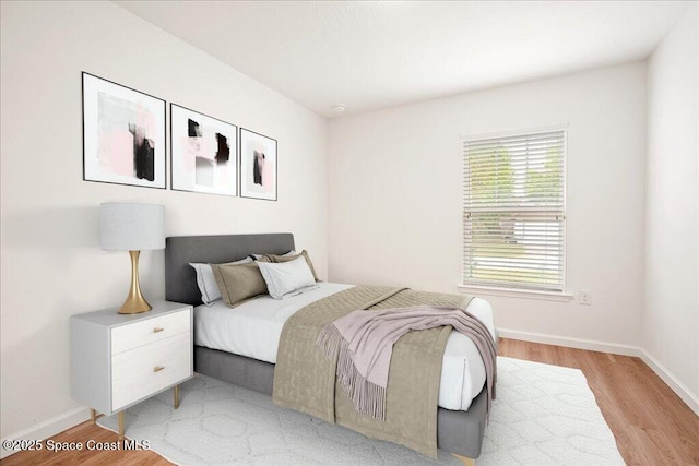 bedroom with baseboards and light wood-style floors