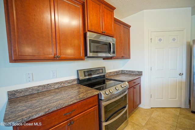 436 Great Falls Ln SW, Palm Bay, FL 32908 - kitchen with light tile patterned flooring, dark countertops, appliances with stainless steel finishes, and a textured ceiling