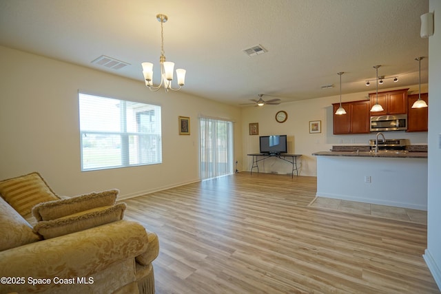 436 Great Falls Ln SW, Palm Bay, FL 32908 - living room featuring light wood-style floors, baseboards, ceiling fan with notable chandelier, and visible vents