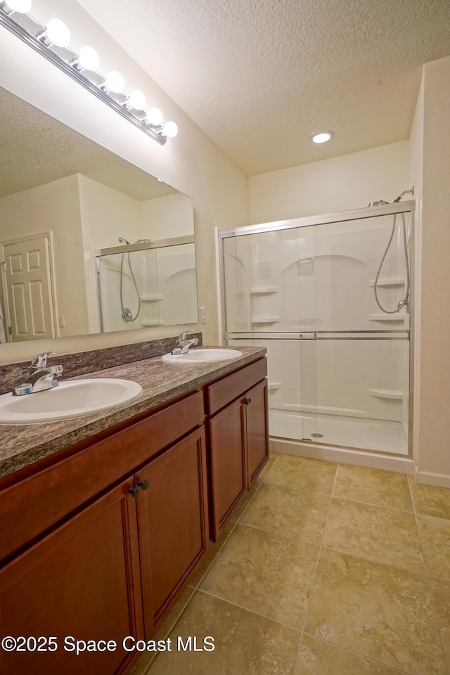 436 Great Falls Ln SW, Palm Bay, FL 32908 - full bathroom with double vanity, a textured ceiling, a sink, and a stall shower