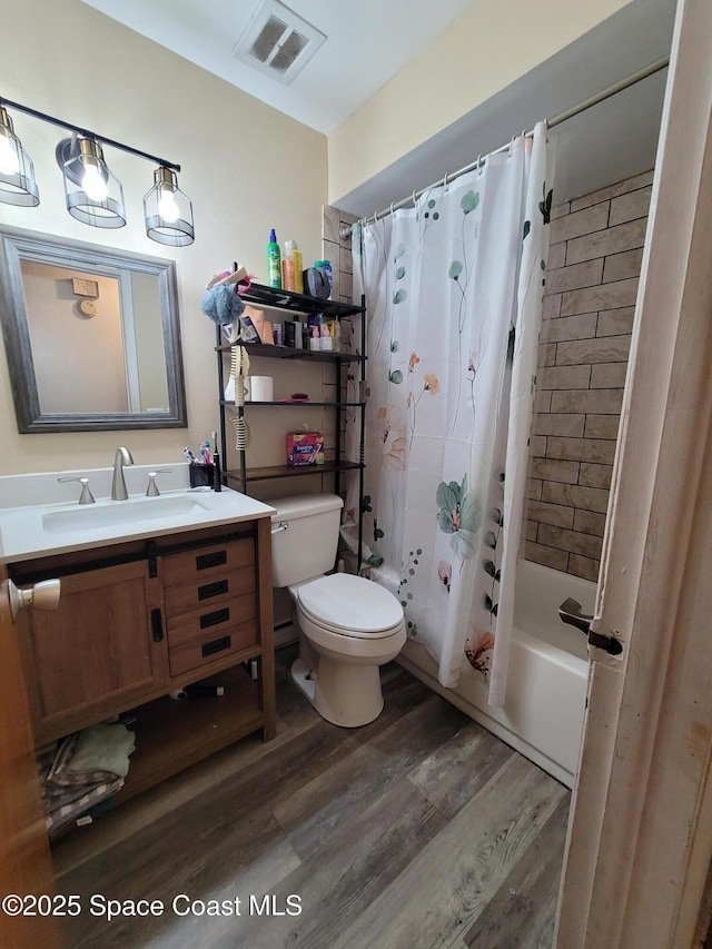 4805 Worth Ave, Titusville, FL 32780 - full bathroom with vanity, toilet, wood finished floors, shower / tub combo, and visible vents
