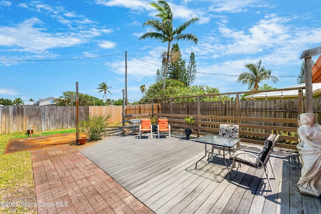wooden terrace with a fenced backyard
