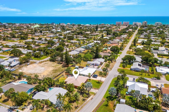 aerial view of property's location featuring a large body of water and nearby suburban area