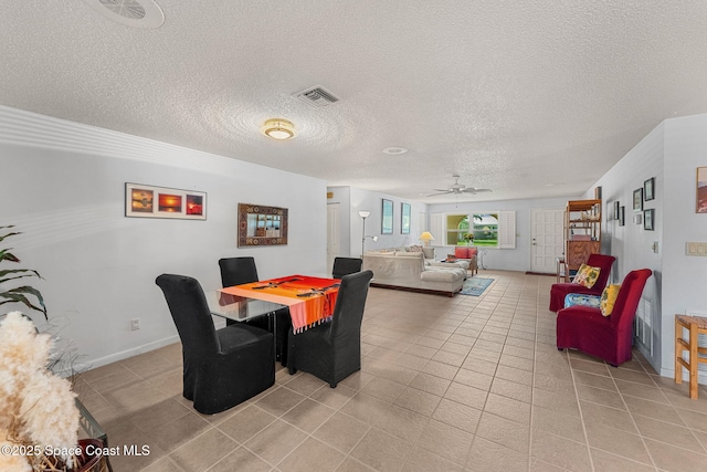 dining room featuring ceiling fan, light tile patterned floors, a textured ceiling, and baseboards