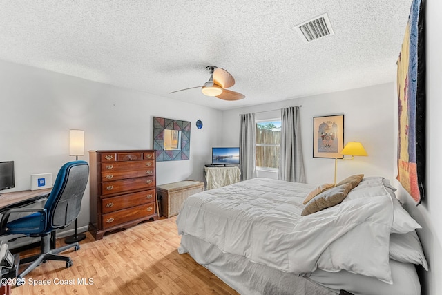 bedroom featuring wood finished floors, a textured ceiling, and a ceiling fan