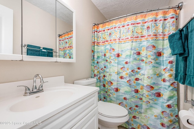 full bathroom with vanity, a textured ceiling, a shower with shower curtain, and toilet