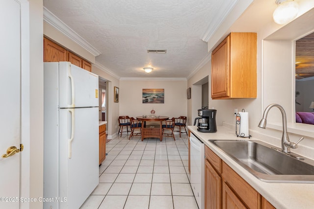 kitchen with visible vents, white appliances, light countertops, a sink, and light tile patterned floors