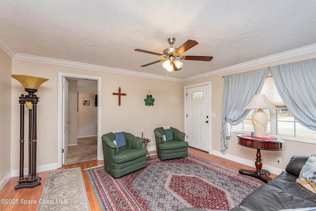 living area featuring ceiling fan, ornamental molding, and wood finished floors