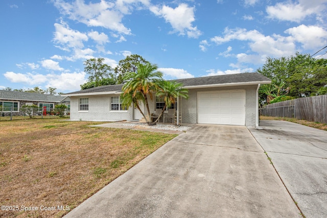 ranch-style house featuring an attached garage, fence, driveway, and a front yard