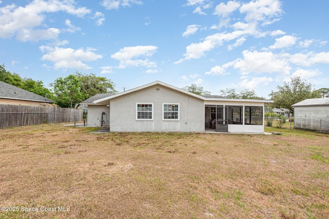 back of property with a lawn, a fenced backyard, a sunroom, and stucco siding