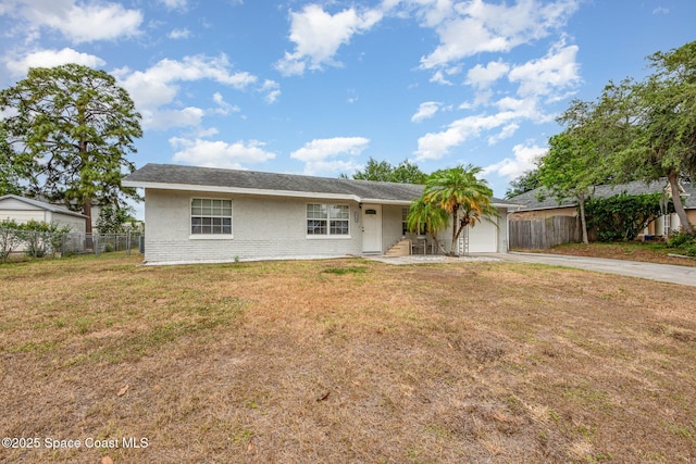 ranch-style house with fence, an attached garage, a front lawn, brick siding, and driveway