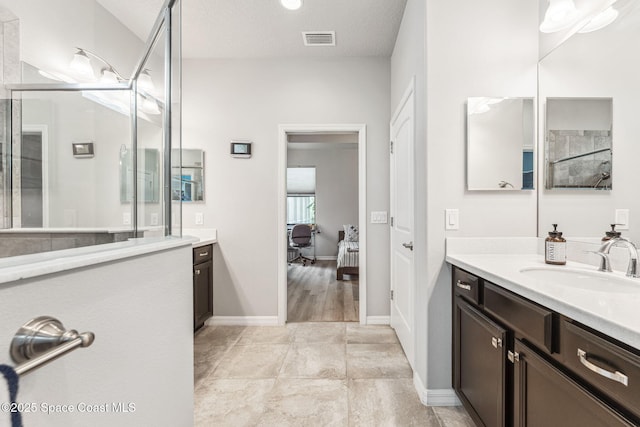 ensuite bathroom with visible vents, tile patterned flooring, a stall shower, vanity, and ensuite bathroom