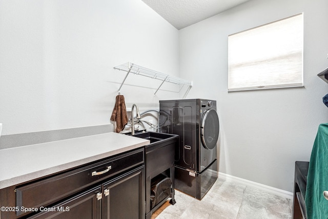 clothes washing area featuring washer / dryer, baseboards, and cabinet space