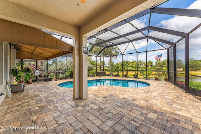pool featuring a patio and glass enclosure