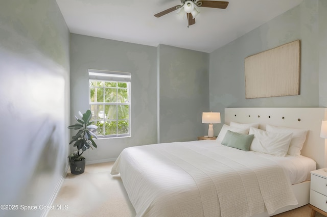 carpeted bedroom featuring baseboards and ceiling fan