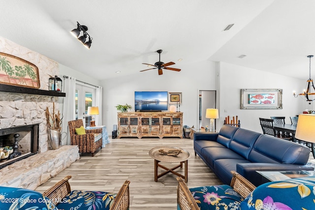 320 Amberjack Pl, Melbourne Beach, FL 32951 - living room featuring visible vents, lofted ceiling, a fireplace, light wood-type flooring, and ceiling fan with notable chandelier