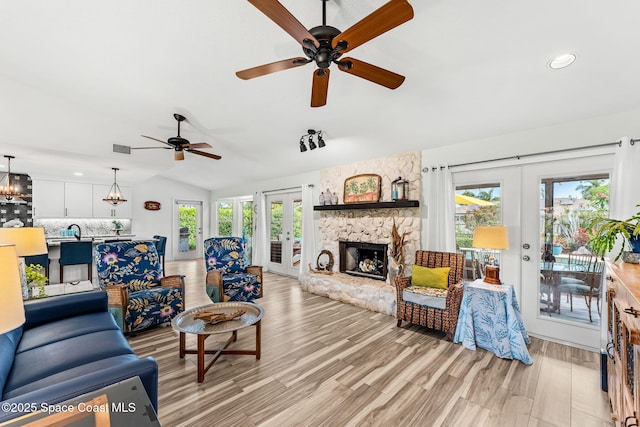 320 Amberjack Pl, Melbourne Beach, FL 32951 - living area with ceiling fan, french doors, a stone fireplace, visible vents, and light wood-style flooring