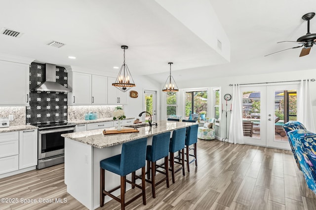 320 Amberjack Pl, Melbourne Beach, FL 32951 - kitchen with wall chimney range hood, visible vents, tasteful backsplash, a sink, and stainless steel electric stove
