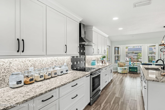 320 Amberjack Pl, Melbourne Beach, FL 32951 - kitchen with wall chimney range hood, stainless steel range with electric cooktop, a sink, white cabinetry, and visible vents