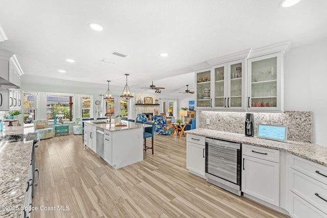 320 Amberjack Pl, Melbourne Beach, FL 32951 - kitchen with decorative backsplash, ceiling fan, a kitchen bar, wine cooler, and white cabinetry