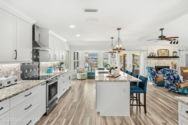 320 Amberjack Pl, Melbourne Beach, FL 32951 - kitchen with visible vents, electric range, open floor plan, wall chimney range hood, and french doors