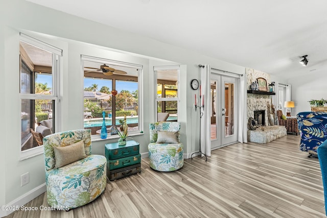 320 Amberjack Pl, Melbourne Beach, FL 32951 - interior space featuring a fireplace, french doors, a ceiling fan, baseboards, and wood finished floors