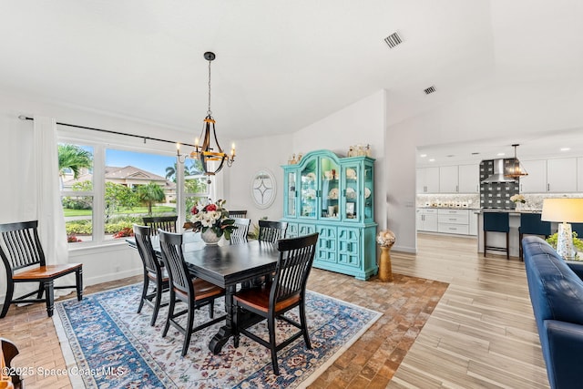 320 Amberjack Pl, Melbourne Beach, FL 32951 - dining area featuring an inviting chandelier, visible vents, lofted ceiling, baseboards, and light wood-type flooring