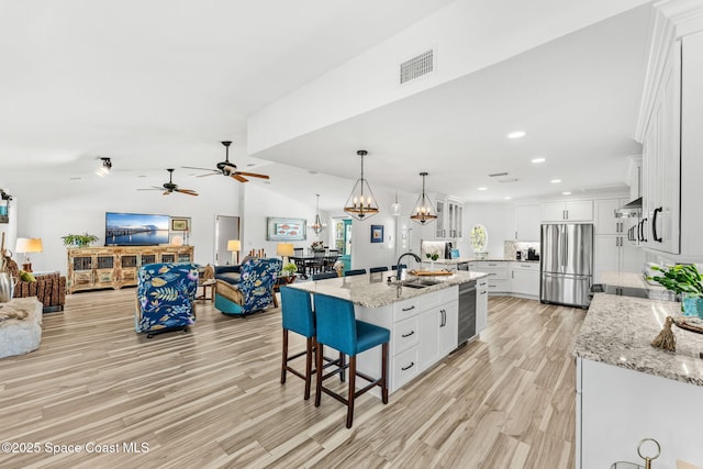 320 Amberjack Pl, Melbourne Beach, FL 32951 - kitchen with a sink, ceiling fan with notable chandelier, stainless steel appliances, light wood-type flooring, and visible vents