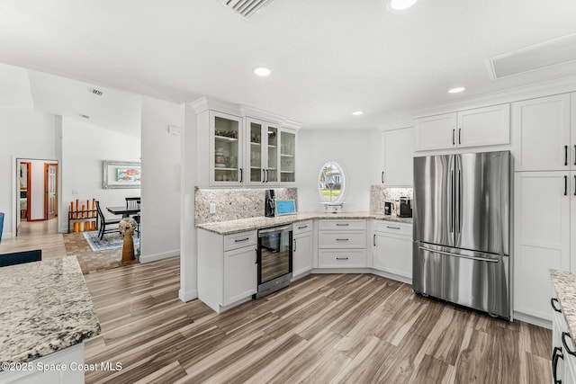 320 Amberjack Pl, Melbourne Beach, FL 32951 - kitchen featuring white cabinets, freestanding refrigerator, beverage cooler, and visible vents