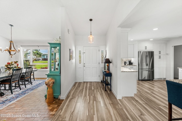 320 Amberjack Pl, Melbourne Beach, FL 32951 - entrance foyer featuring an inviting chandelier, baseboards, light wood-style floors, and recessed lighting