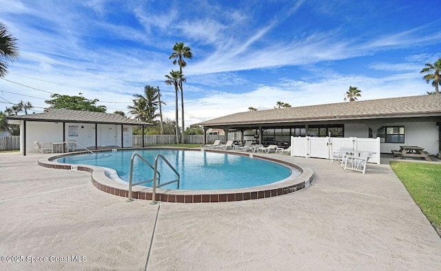 pool with a patio and fence