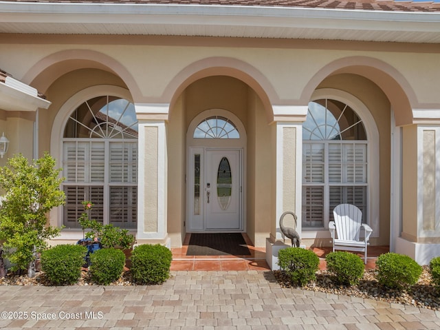 doorway to property featuring stucco siding and covered porch