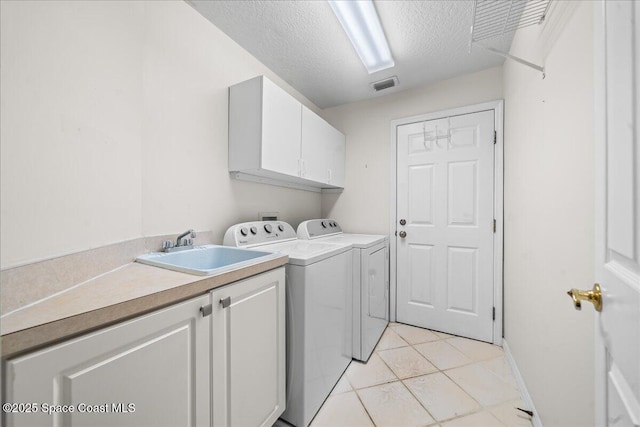 laundry room with cabinet space, light tile patterned floors, visible vents, a textured ceiling, and washer and dryer