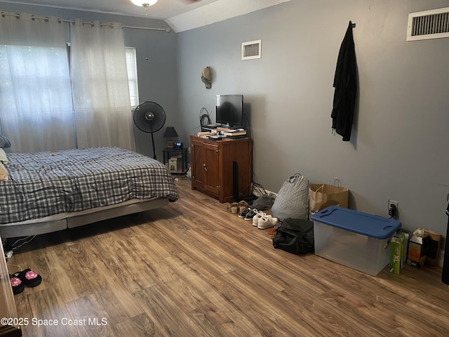 bedroom featuring visible vents, wood finished floors, and lofted ceiling