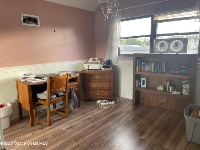 home office featuring vaulted ceiling, wood finished floors, and visible vents