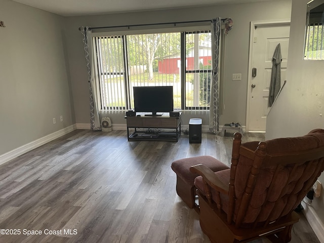 living area featuring baseboards and wood finished floors