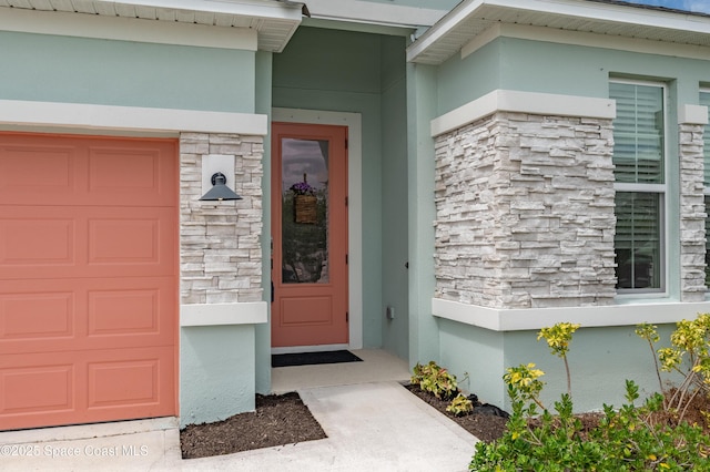 property entrance featuring stucco siding and stone siding