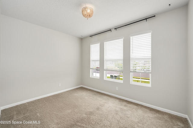 empty room featuring baseboards and carpet