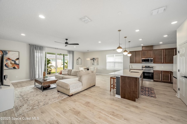 living room featuring visible vents, baseboards, ceiling fan, recessed lighting, and light wood-type flooring