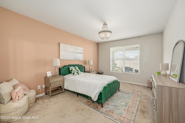 bedroom with a notable chandelier, baseboards, and light colored carpet