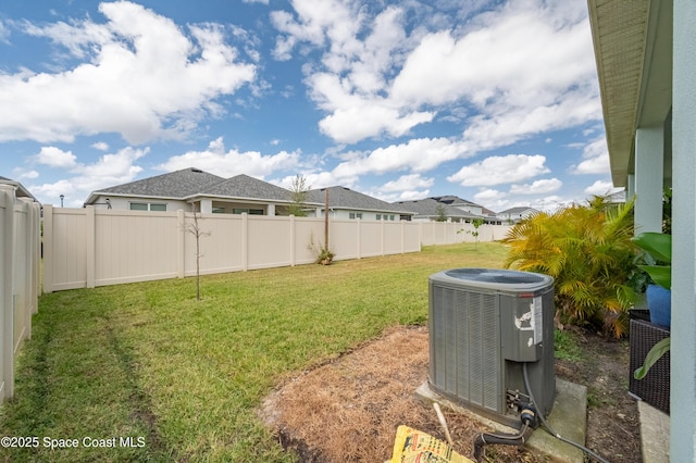 view of yard with central air condition unit and a fenced backyard