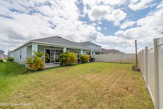 view of yard with a patio, ceiling fan, a fenced backyard, and central AC