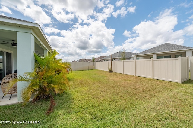 view of yard featuring a fenced backyard and ceiling fan