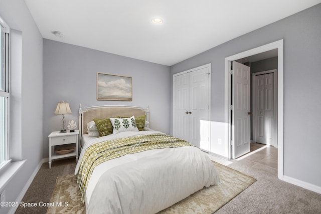 carpeted bedroom with baseboards and a closet