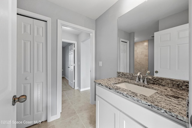 bathroom featuring tile patterned flooring, a closet, vanity, and baseboards