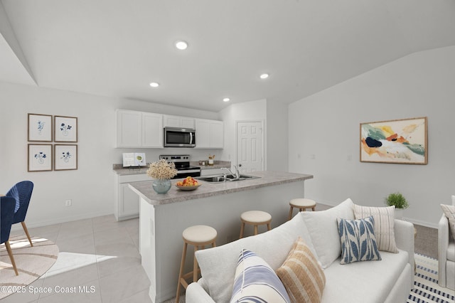 453 Larino Rd SW, Palm Bay, FL 32908 - kitchen with recessed lighting, a sink, stainless steel appliances, a breakfast bar, and white cabinets