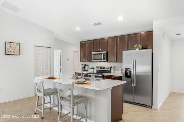 1591 Palatka Rd SE, Palm Bay, FL 32909 - kitchen with light countertops, a kitchen island with sink, stainless steel appliances, and visible vents