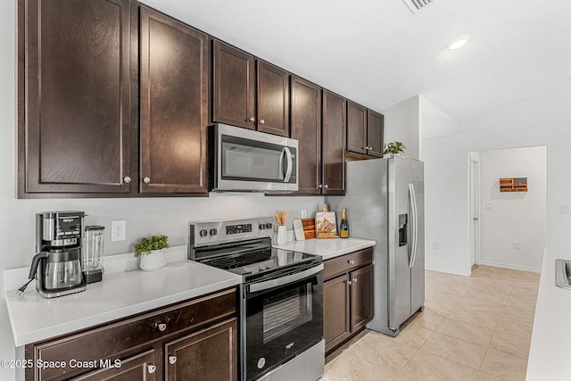 1591 Palatka Rd SE, Palm Bay, FL 32909 - kitchen featuring dark brown cabinetry, light countertops, baseboards, stainless steel appliances, and light tile patterned flooring