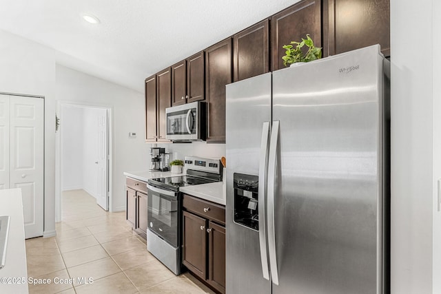 1591 Palatka Rd SE, Palm Bay, FL 32909 - kitchen with appliances with stainless steel finishes, dark brown cabinets, light countertops, lofted ceiling, and light tile patterned flooring