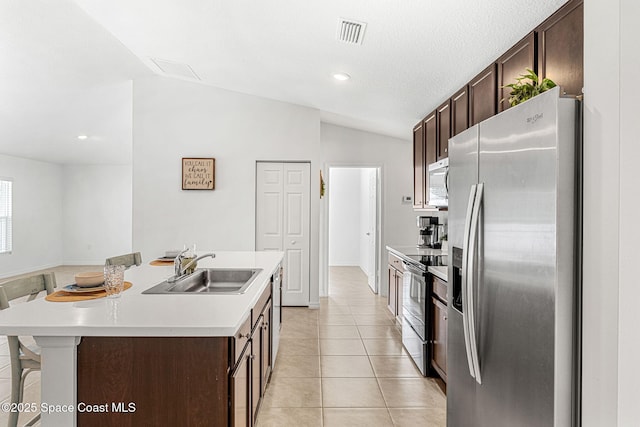 1591 Palatka Rd SE, Palm Bay, FL 32909 - kitchen with dark brown cabinets, appliances with stainless steel finishes, a sink, and lofted ceiling
